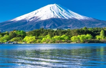Mount Fuji with snow on top and trees around it
Description automatically generated